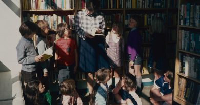 Young Black students reading together in a library setting with diverse book selections