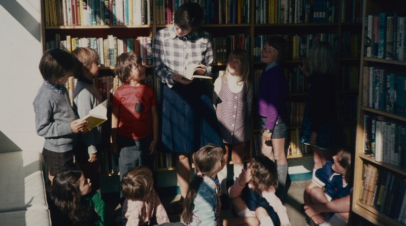Young Black students reading together in a library setting with diverse book selections