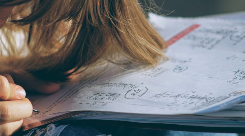 A student looking anxious while studying mathematics at a desk