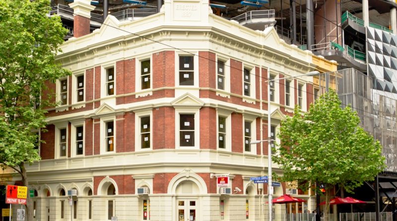 Modern student accommodation building in Melbourne CBD with city skyline
